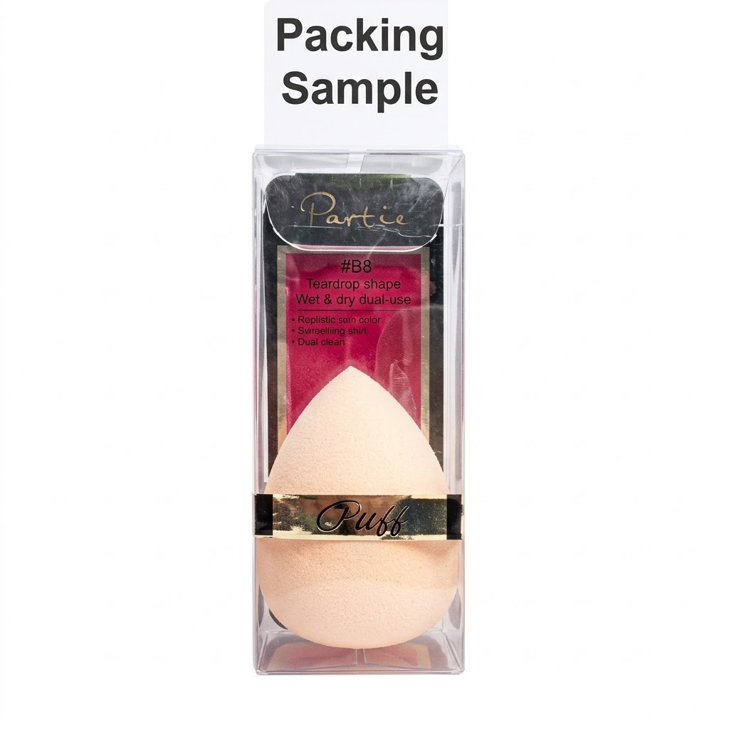 A clear plastic box contains a light-beige teardrop makeup sponge. The box has a gold and black band with the word 'Puff' printed on it. Above the box is a white card with the words 'Packing Sample' on it.